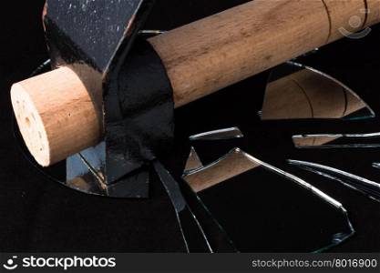 hammer broken mirror pieces on a black background