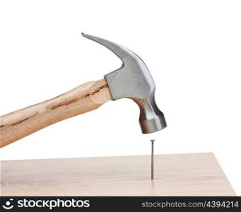 Hammer hitting a nail into a wood isolated on white background