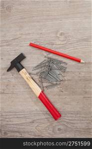 Hammer, nails and a red pencil for carpentry