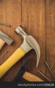 hammer tool and nail on wooden background