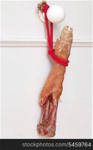 Hammon pork leg hanging on white door&#xA;