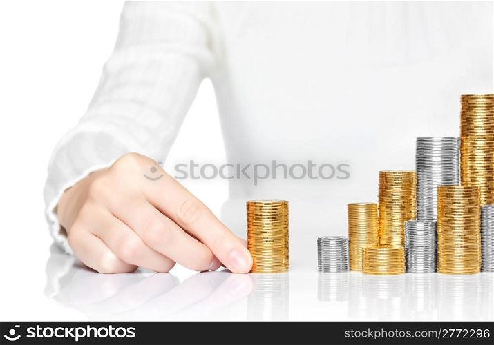 Hand adding a stack of coins to savings
