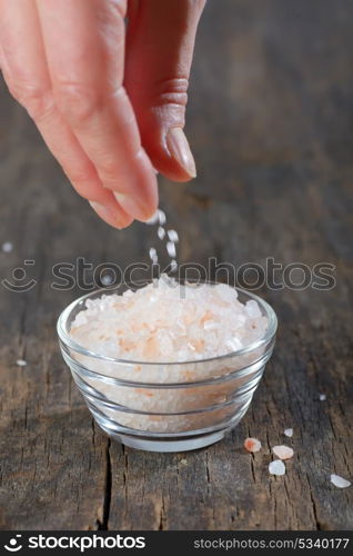 Hand adding Pink salt from the Himalayas