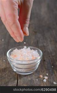 Hand adding Pink salt from the Himalayas