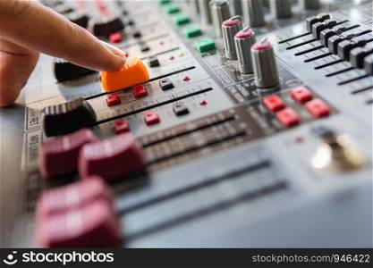 Hand adjusting audio mixer sound