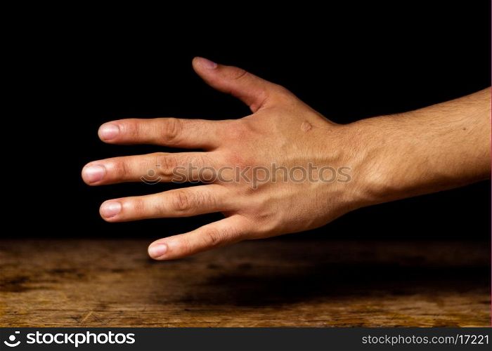Hand against black background
