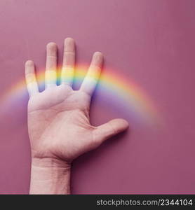 hand and rainbow on the pink wall, lgbt symbol