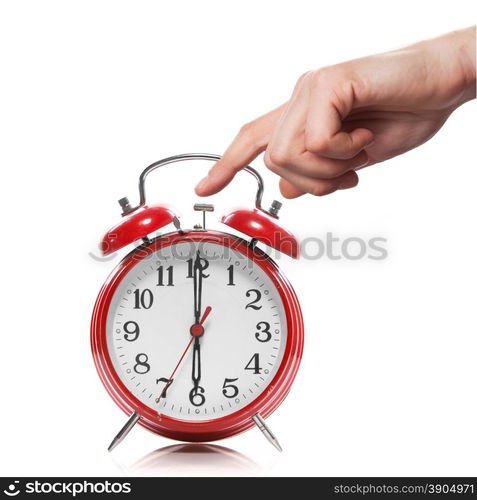 hand and red old style alarm clock isolated on white