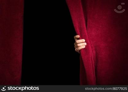 Hand appearing beneath the curtain. Red curtain.
