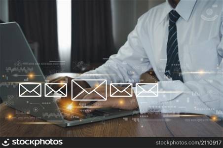 Hand Business man using Laptop with email icon, Emails or Electronic mail spam concept. Postal envelopes icons. Digital finance technology marketing. Social media. Global customer network connection.