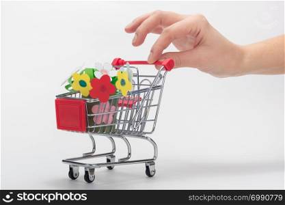 Hand carries a grocery cart with a children&rsquo;s crafts bouquet of flowers
