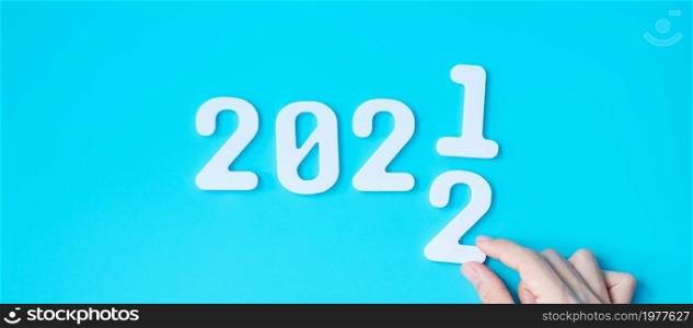 hand change 2021 to 2022 number on blue background. Plan, finance, Resolution, strategy, solution, goal, business and New Year holiday concepts
