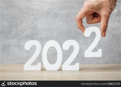 hand change 2021 to 2022 number on table. Plan, finance, Resolution, strategy, solution, goal, business and New Year holiday concepts