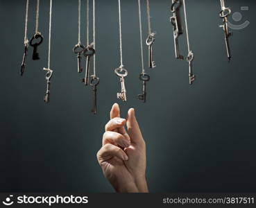 Hand choosing a hanging key amongst other ones.