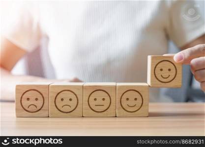 Hand choosing smile face from Emotion block.  customer review, good experience, positive feedback, satisfaction, survey, rating service, assessment, mood, world mental health day concept