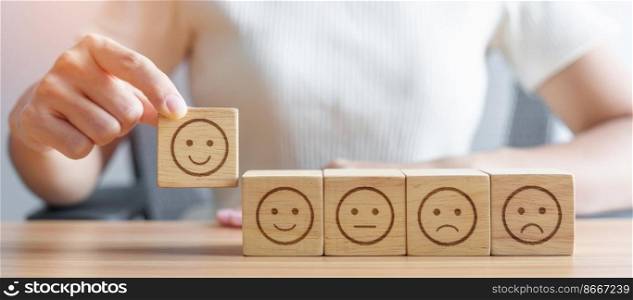 Hand choosing smile face from Emotion block for customer review, good experience, positive feedback, satisfaction, survey, evaluation, assessment, mood, world mental health day concept