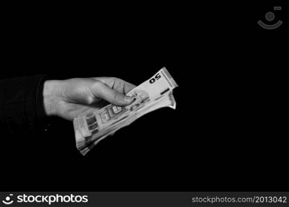 Hand counting holding and showing euro money or giving money. World money concept, 50 EURO banknotes EUR currency isolated on black with copy space. Concept of rich people, saving or spending money
