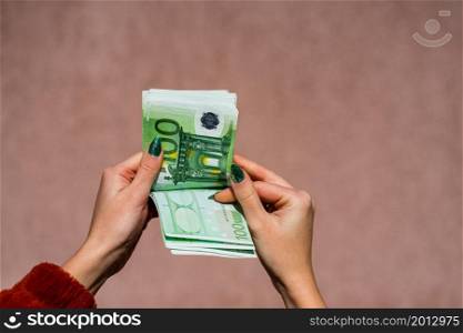 Hand couting holding and showing euro money or giving money. World money concept, 100 EURO banknotes EUR currency isolated with copy space. Concept of rich business people, saving or spending money.