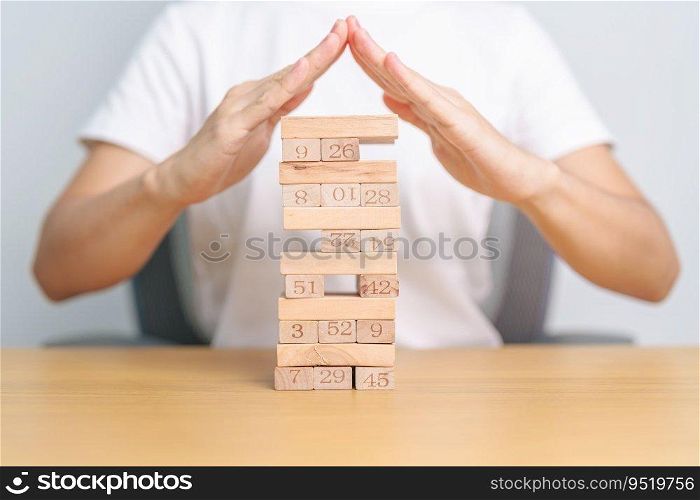 hand cover wooden block on the tower. Business planning, Risk Management, Solution, insurance and strategy Concepts