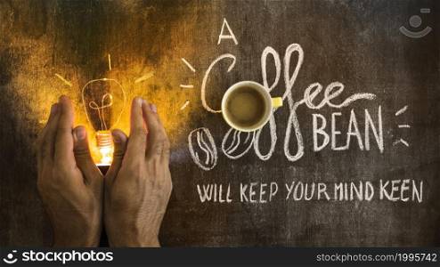 hand covering illuminated light bulb with text chalkboard