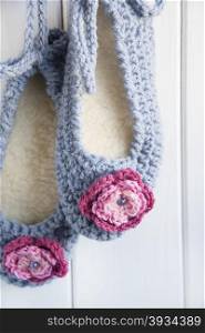 Hand Crocheted Womens Slippers, Hanging Against A Wooden Door