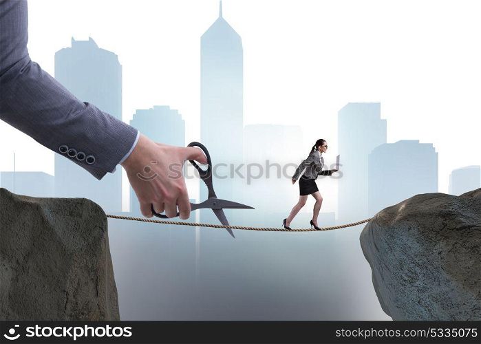 Hand cutting the rope under businesswoman tightrope walker