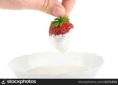 Hand dip strawberry in cream on white