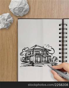 hand drawing house on wrinkled paper with wooden table as concept 
