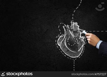 Hand drawing human heart with chalk on black. Heart surgery