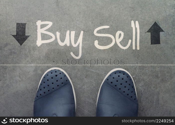 Hand drawn BUY or SELL design word on front of business man feet as concept