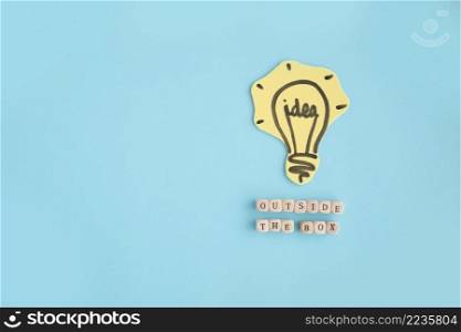 hand drawn idea light bulb outside box text made with blocks blue background