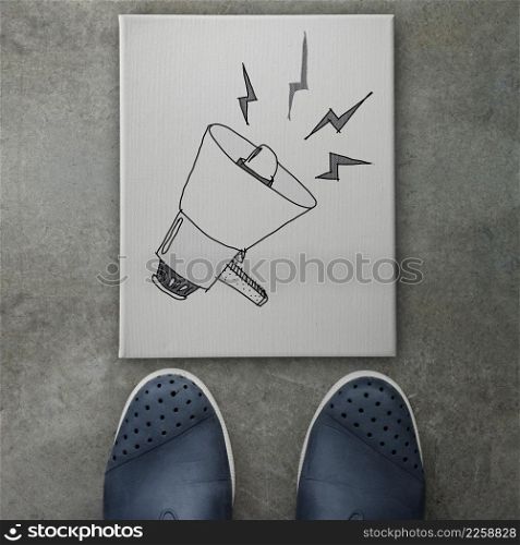 Hand drawn loudspeaker design doodle icon on front of business man feet as concept