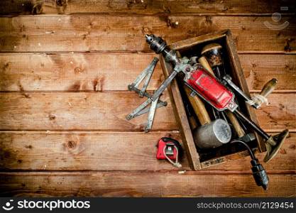Hand drill with various drills. On a wooden background. High quality photo. Hand drill with various drills.