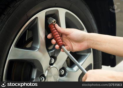 Hand fill air into a car tire.