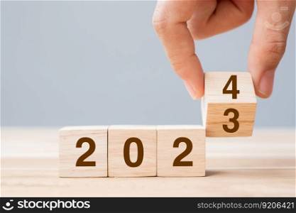 hand flip cube block 2023 to 2024 text on table. Resolution, review, strategy, end year, goal, business and New Year holiday concepts