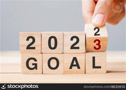 hand flipping block 2022 to 2023 GOAL text on table. Resolution, strategy, plan, motivation, reboot, business and New Year holiday concepts