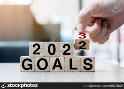 hand flipping block 2022 to 2023 GOAL text on table. Resolution, strategy, plan, motivation, reboot, business and New Year holiday concepts