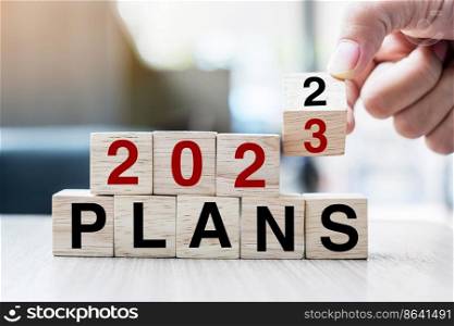 hand flipping block 2022 to 2023 PLAN text on table. Resolution, strategy, goal, motivation, reboot, business and New Year holiday concepts