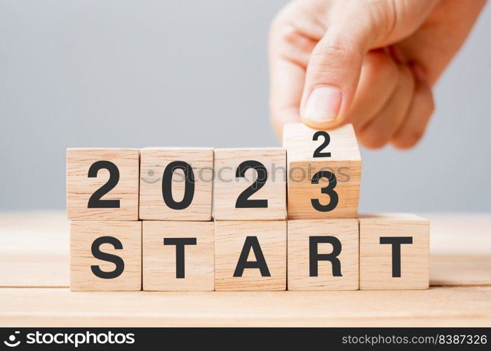 hand flipping block 2022 to 2023 START text on table. Resolution, strategy, goal, motivation, reboot, business and New Year holiday concepts