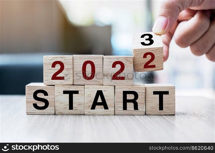 hand flipping block 2022 to 2023 START text on table. Resolution, strategy, goal, motivation, reboot, business and New Year holiday concepts