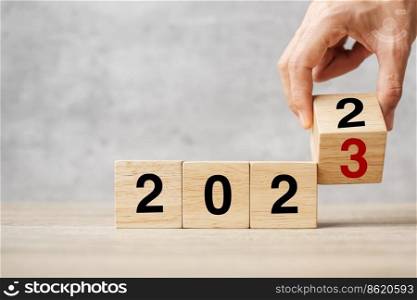 hand flipping block 2022 to 2023 text on table. Resolution, strategy, plan, goal, motivation, reboot, business and New Year holiday concepts