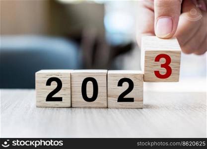 hand flipping block 2022 to 2023 text on table. Resolution, strategy, plan, goal, motivation, reboot, business and New Year holiday concepts