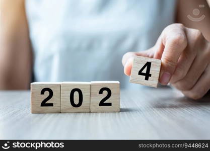 hand flipping block 2023 to 2024 text on table. Resolution, strategy, plan, goal, motivation, reboot, business and New Year holiday concepts