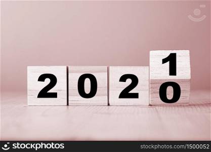 Hand flipping wooden blocks for change year 2020 to 2021 . New year and holiday concept.