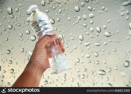 hand for bottle of water on drop water background