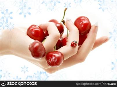 hand full of red cherries with snowflakes