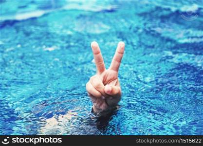 hand gesture of happy kid in swimming pool