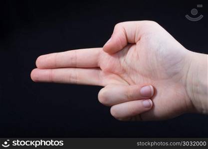 Hand gesture pointing fingers pistol-like handgun . Hand gesture pointing fingers pistol-like handgun on black
