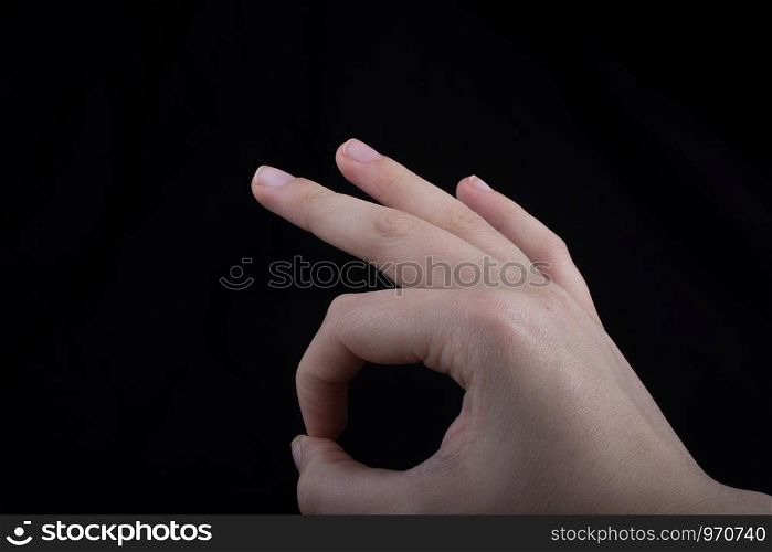 Hand gesturing sign ok okay agree on black background