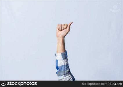 Hand gesturing the letter A in sign language on isolated background. Man hand gesturing the letter A of the alphabet isolated. Letters of the alphabet in sign language.